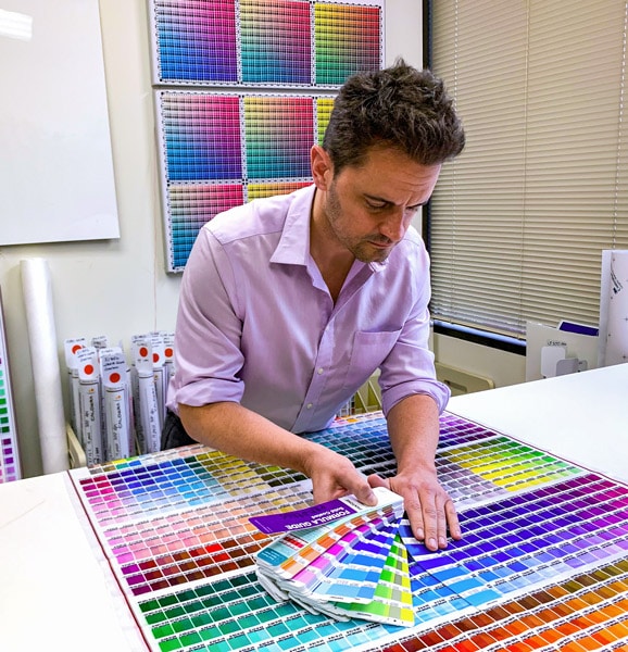 Man using Pantone swatches to color match