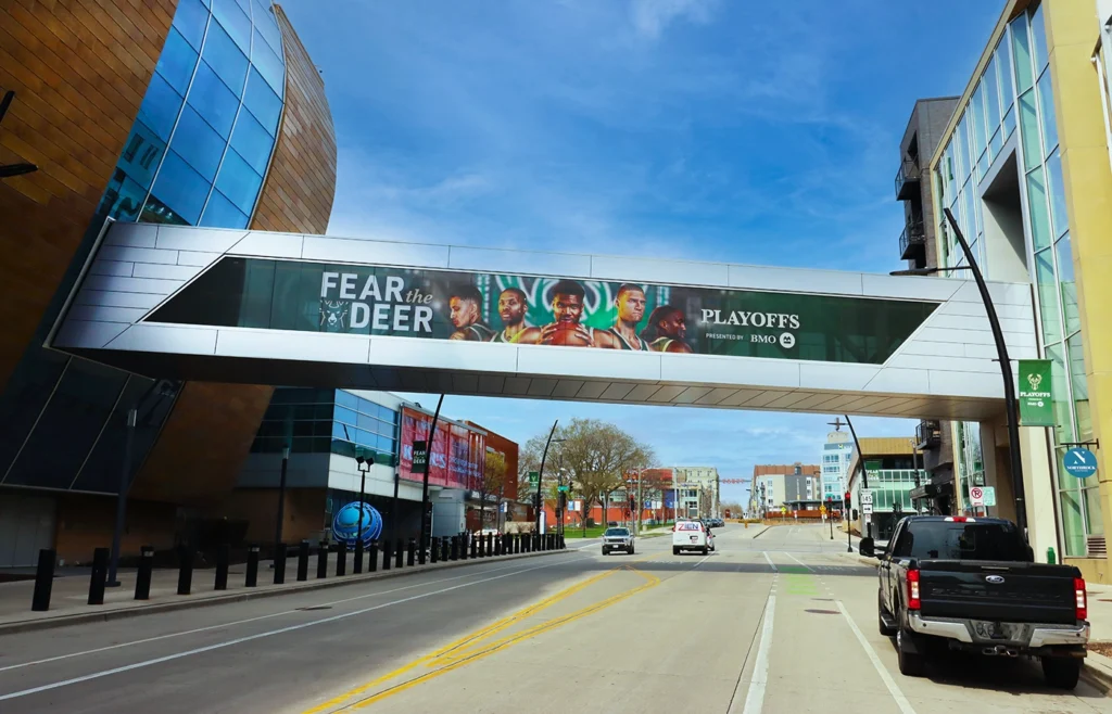 A vinyl designed skybridge outside an arena displaying a promotion for the Milwaukee Bucks' playoffs